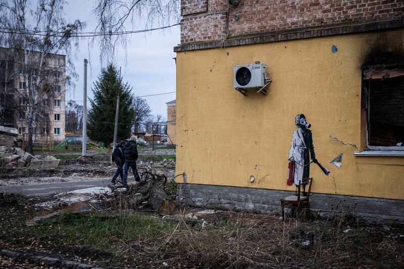 A figure in a dressing gown holds a fire extinguisher and wears a gas mask in Hostomel near Antonov International Airport in Kyiv Region. Getty 