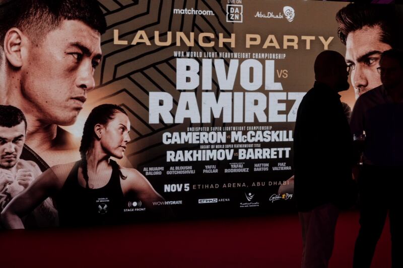 A large billboard promoting the boxing event is displayed at the launch party.
