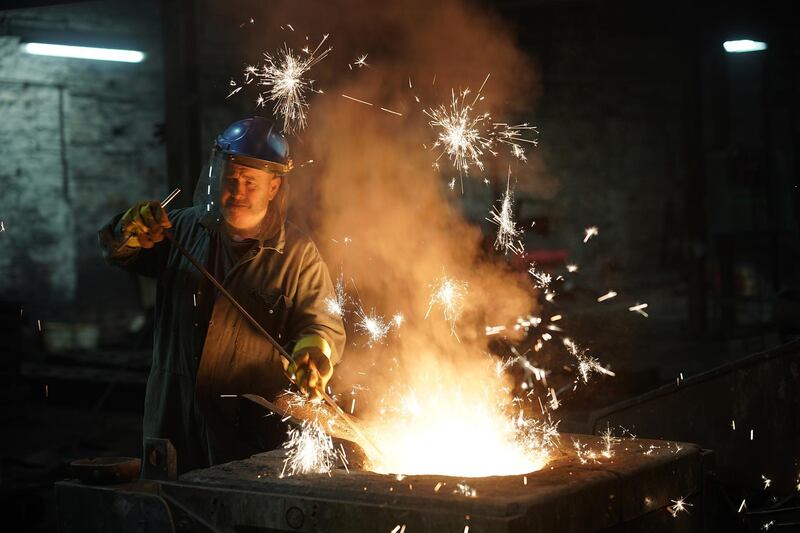 WALSALL, ENGLAND - FEBRUARY 21: Furnace man Paul Taylor tends the iron furnace at Kirkpatrick Foundry on February 21, 2018 in Walsall, England. Kirkpatrick Ltd is the oldest established manufacturer of black iron door and window furniture in the UK. The Black Country factory is the only manufacturer of traditional black ironmongery left in the UK, in which molten iron is poured from the furnace into moulds made by skilled pattern makers. The skills and craftsmanship of the workforce has been handed down through generations since the company was founded by William Kirkpatrick in Walsall in 1855 and still exports its reknowned iron work across the world. (Photo by Christopher Furlong/Getty Images)