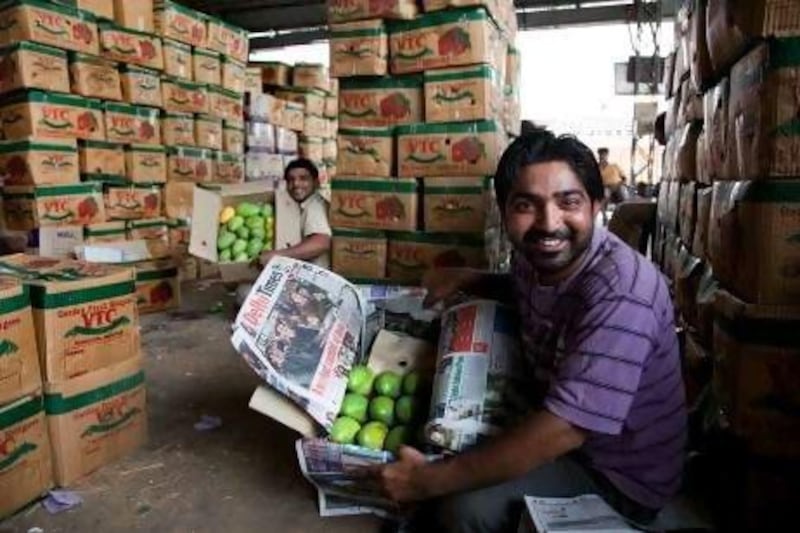 31 May 2102, New Delhi, India: Wholesale mango seller Salim (foreground) at Azadpur market in North Delhi surrounded by boxes of fruit being readied to transport around the country. The low yield of mango this year is driving up prices in India. Picture by Graham Crouch/The National