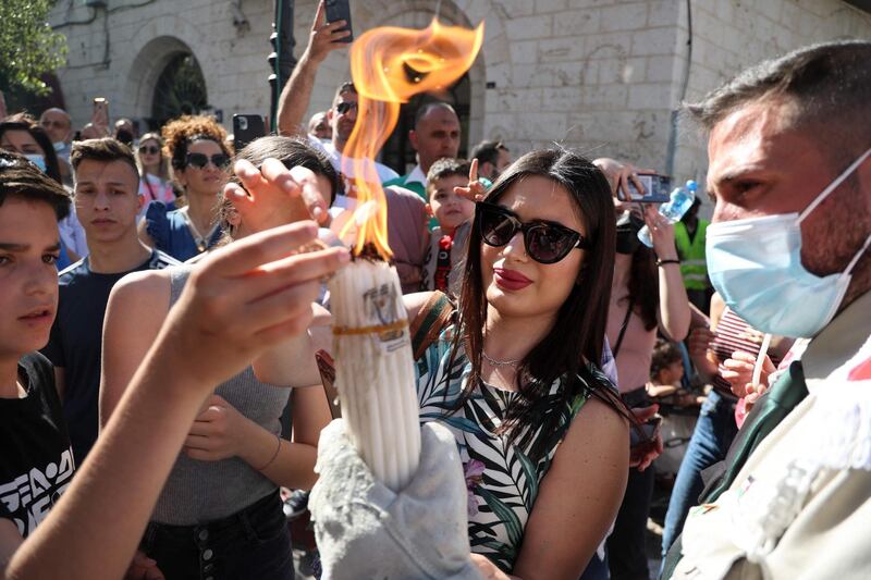 Palestinians share the Holy Fire in the streets of the occupied West Bank city of Ramallah. AFP