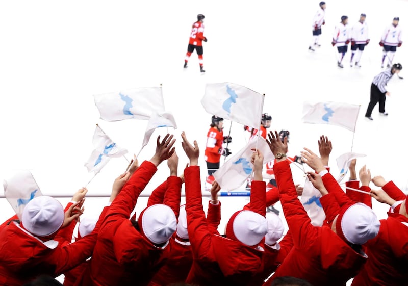 Ice Hockey – Pyeongchang 2018 Winter Olympics – Women Preliminary Round Match - Switzerland v Korea - Kwandong Hockey Centre, Gangneung, South Korea – February 10, 2018 - North Korea's cheer squad wave the unification flag. REUTERS/Grigory Dukor