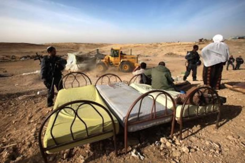epa02505117 Bedouins with their furniture, including three beds, which were removed from the living structure being demolished in the Bedouin site of Al Akrib in the Negev Desert, near Beersheba, Israel as police keep people from interferring with the demolition, early on 23 December 2010. Israeli authorities have razed what they call this 'unrecognized village,' which includes a cemetery, eight times as they try to get the Bedouins to move to the nearby Bedouin city of Rahat, which the Bedouins refuse to do.  EPA/JIM HOLLANDER *** Local Caption ***  02505117.jpg
