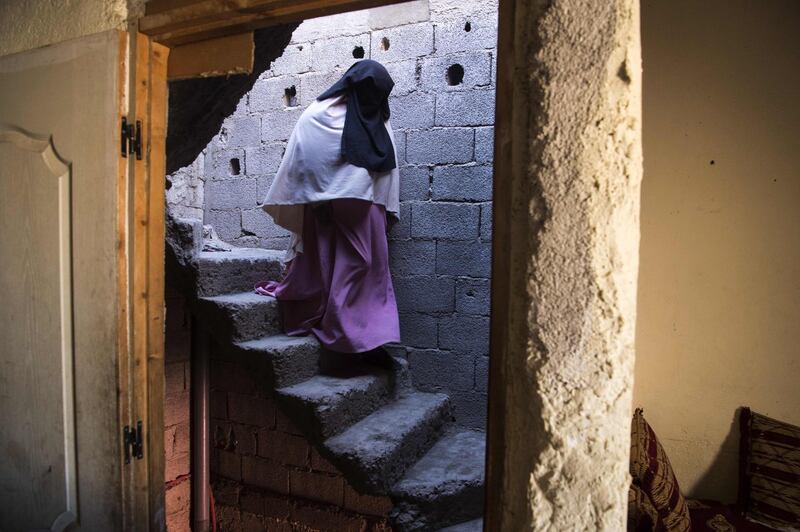 Fatima el-Khayali, the aunt of Abdelrahim el-Khayali, one of the suspects who were arrested following the murder of two Scandinavian hikers in Morocco's High Atlas mountains, descends the stairs of her house in the neighbourhood of Azzouzia in the capital Marrakesh. AFP