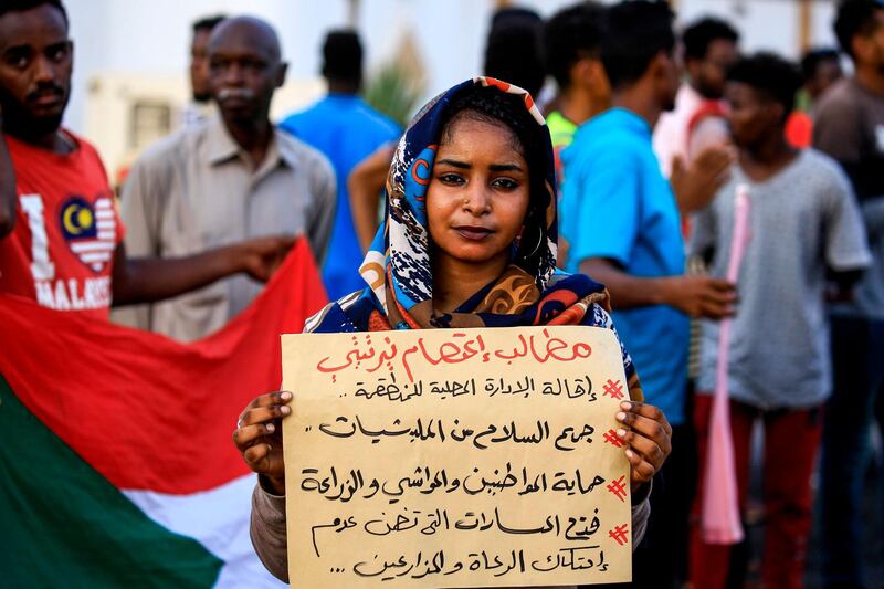 A demonstrator stands with a sign reading in Arabic "demands of the Nertiti sit-in: sacking the local authority; collecting arms from militias; protecting citizens, cattle, and farmland; opening routes that guarantee no friction between farmers and shepherds", during a protest outside the Sudanese Professionals Association in the Garden City district of Sudan's capital Khartoum, in solidarity with the people of the Nertiti region of Central Darfur province in the country's southwest. AFP