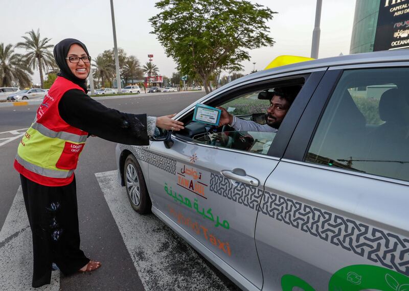 Abu Dhabi, United Arab Emirates, May 7, 2019.    Red Crescent volunteers and Abu Dhabi Police distribute food to motorists during iftar at the corner of 11th St. and 18th Sports City area.--  Hana Al Braeiki distributes food to motorists.
Victor Besa/The National
Section:  NA
Reporter:  Haneen Dajani