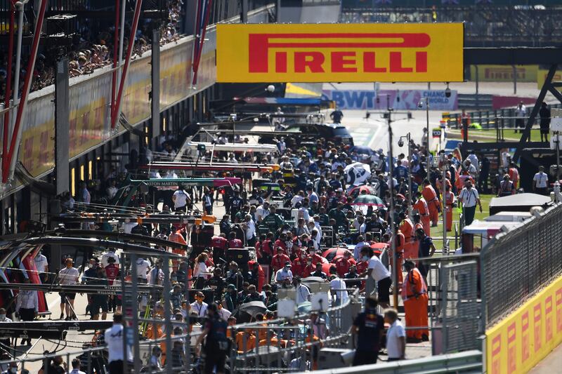 Cars back in the pit lane after the early crash.