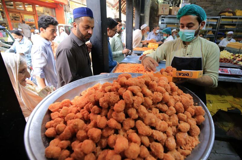 People buy sweets for the Eid al-Fitr festival, the celebrations marking the end of the holy fasting month of Ramadan in Peshawar, Pakistan. EPA
