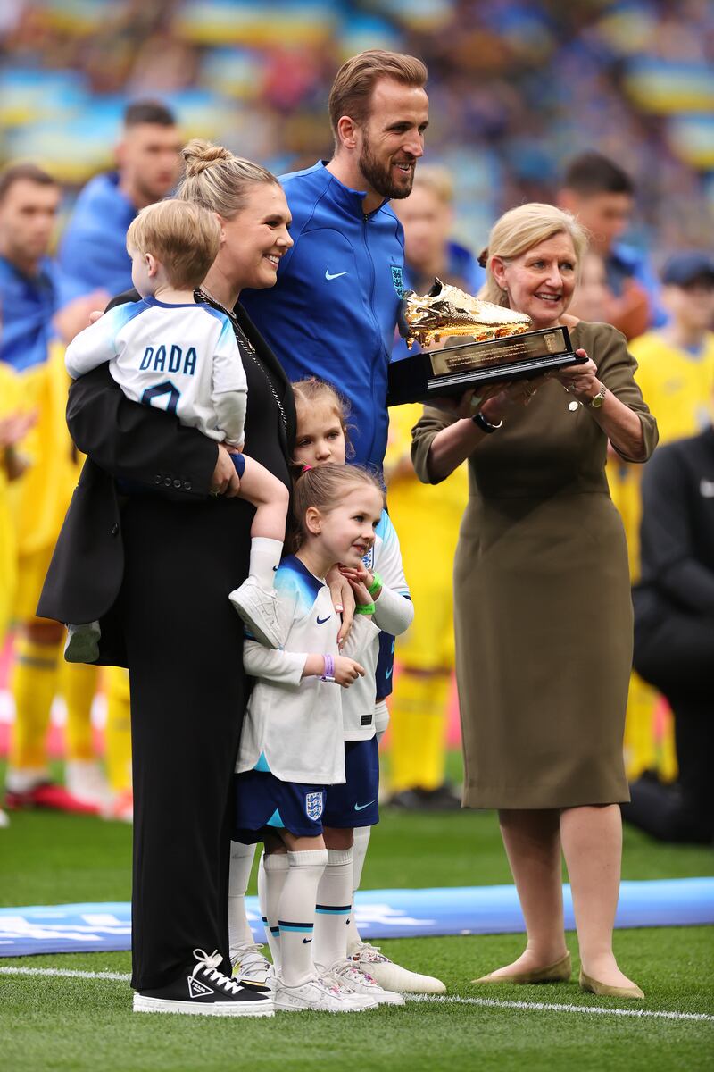 Harry Kane, with his wife Katie and children Ivy, Vivienne and Louis, is presented with a Golden Boot trophy by FA chairwoman Debbie Hewitt before the game against Ukraine at Wembley on Sunday. He became England's all-time leading scorer when he notched his 54th goal in the game against Italy on Thursday. Getty 