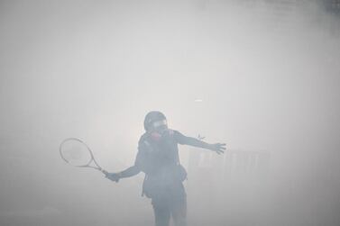 A protester uses a tennis racquet to hit back tear gas canisters during clashes with police after an anti-government rally in Tsuen Wan district in Hong Kong, China. Getty