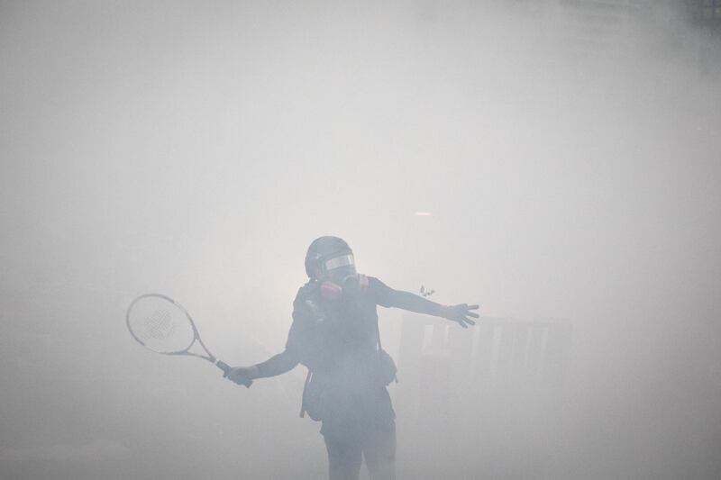 HONG KONG, CHINA - AUGUST 25: A protester uses a tennis racquet to hit back tear gas canisters during clashes with police after an anti-government rally in Tsuen Wan district on August 25, 2019 in Hong Kong, China. Pro-democracy protesters have continued rallies on the streets of Hong Kong against a controversial extradition bill since 9 June as the city plunged into crisis after waves of demonstrations and several violent clashes. Hong Kong's Chief Executive Carrie Lam apologized for introducing the bill and declared it "dead", however protesters have continued to draw large crowds with demands for Lam's resignation and complete withdrawal of the bill. (Photo by Chris McGrath/Getty Images) *** BESTPIX ***