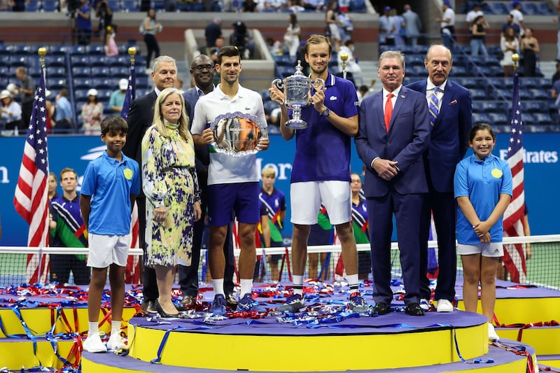 Novak Djokovic of Serbia holds the runner-up trophy alongside Daniil Medvedev of Russia who celebrates with the championship trophy at the USTA Billie Jean King National Tennis Center on September 12, 2021. AFP