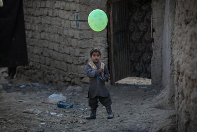 epa08948976 An Afghan internally displaced boy poses for a photograph as he holds a balloon near to a temporary shelter at an Internally Displaced Persons (IDPs) camp on the outskirts of Kabul, Afghanistan on 19 January 2021. Over 18.4 million Afghans including 9.7 million children in Afghanistan desperately need life-saving support, said Save the Children in a statement on 19 January, therefore the NGO is calling for billions of dollars in aid to cope with the challenges.  The NGO says a combination of conflict, poverty, and the Coronavirus pandemic continue to have devastating impacts on the population and continue to fuel humanitarian needs in Afghanistan.  EPA/HEDAYATULLAH AMID