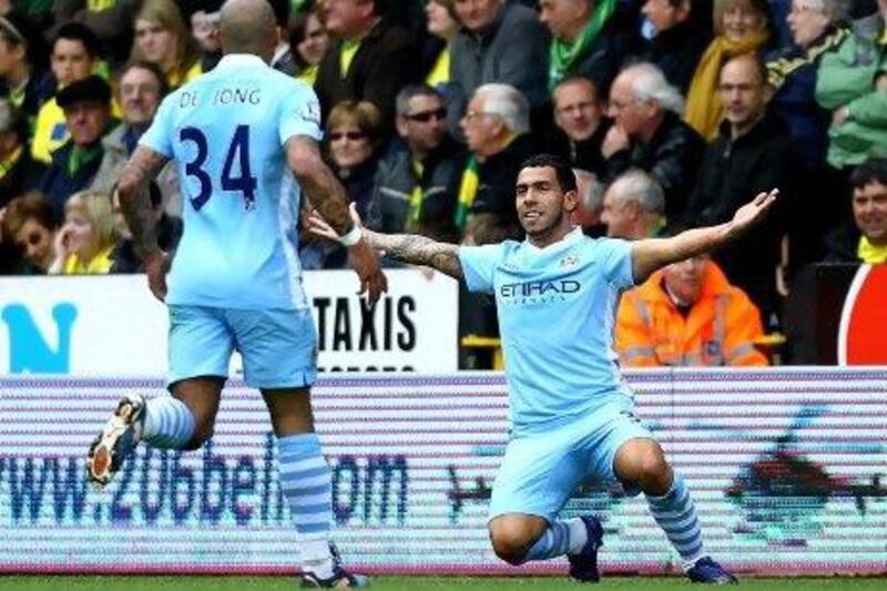 Carlos Tevez, right, the Manchester City forward, celebrates scoring the opening goal against Norwich City with teammate Nigel de Jong at Carrow Road. Matthew Lewis / Getty Images