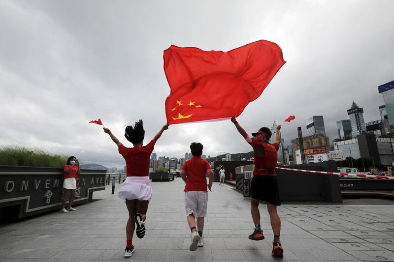 Runners fly the Chinese and Hong Kong flags at Convention Avenue, Hong Kong, marking  the 25th anniversary of the former British colony's handover to China. Reuters