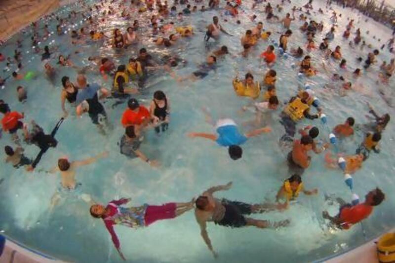 Children and adults took the dive at Yas Waterworld yesterday in a bid to break the Guinness World Record for the largest swimming lesson. Delores Johnson / The National