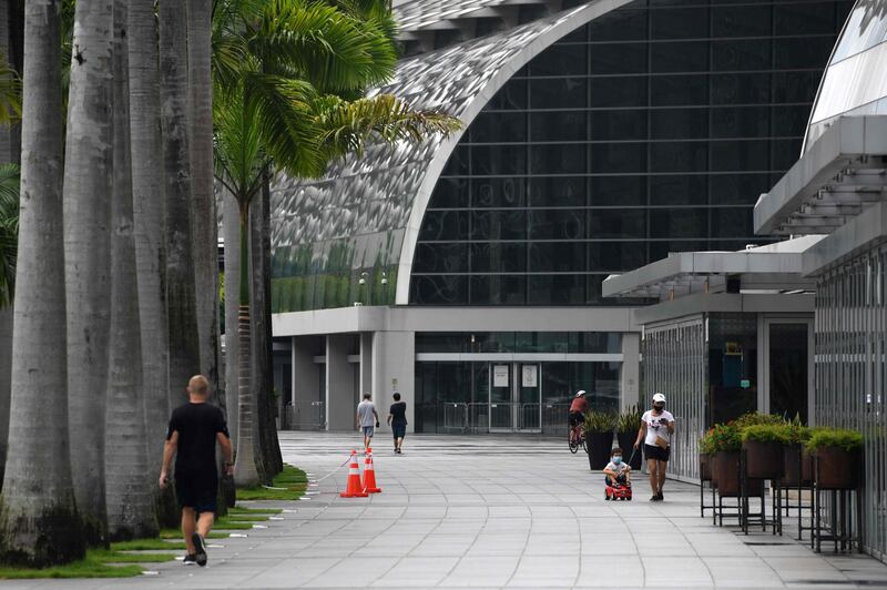 People wear face masks as a preventive measure against the spread of the coronavirus as they walk along the promenade at Marina Bay in Singapore. AFP