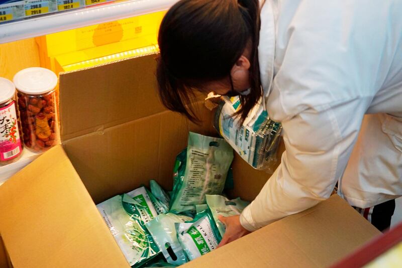 Staffers open a box of face masks at Yifeng Pharmacy in Wuhan, China. AP Photo