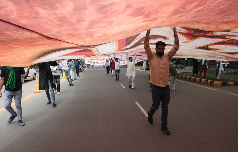 Indian Youth Congress activists hold a huge banner as they take part in a protest march in New Delhi. EPA
