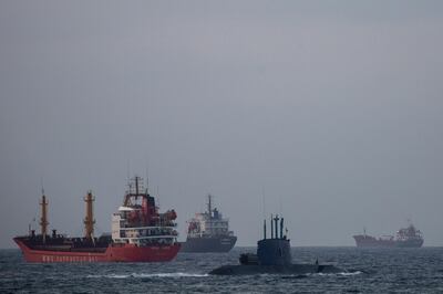 An Israeli military submarine sails past cargo ships in the Mediterranean Sea, Israel, Tuesday, Sept. 29, 2020. After a coronavirus-related delay, Israel's navy is preparing for the long-awaited arrival of its next generation of missile boats - giving it a powerful new tool to defend its strategic natural gas industry from the threat of the Lebanese militant group Hezbollah. (AP Photo/Ariel Schalit)