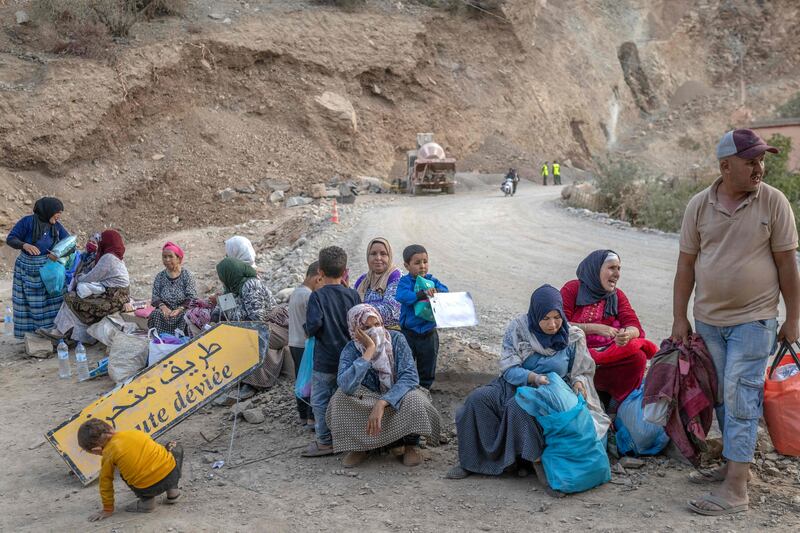 People displaced by the earthquake sit with their belongings by the side of the road between Marrakesh and Taroudant in the Atlas mountains. AFP
