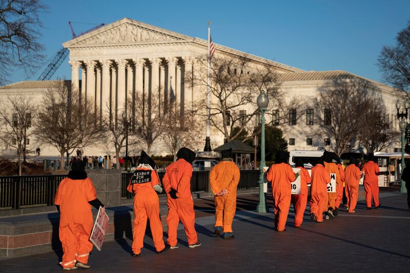 Outside the Supreme Court in Washington, a group of people dressed as prisoners protest against the Guantanamo Bay prison. Reuters