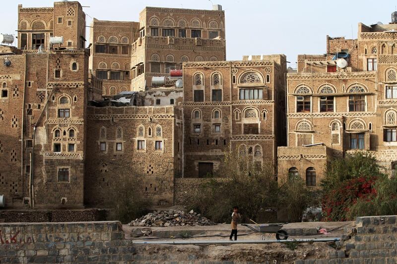 epa07348666 A Yemeni child stands in front of historic buildings in the Old City of Sana'a, Yemen, 06 February 2019. The old quarter of Sana'a, listed as a world heritage site by UNESCO in 1986, has been inhabited for more than 2,500 years. It is made up of some 8,000 buildings, including its distinctive multi-story tower houses, most of them are between 200 and 500 years old.  EPA/YAHYA ARHAB