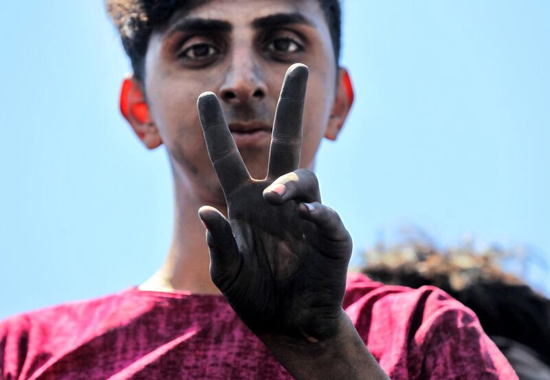 TOPSHOT - An Iraqi protester gestures as he stands on the Al-Jumhuriyah bridge in the capital Baghdad on May 11, 2020, during an anti-government demonstration. Modest anti-government rallies resumed in some Iraqi cities Sunday, clashing with security forces and ending months of relative calm just days after Prime Minister Mustafa Kadhemi's government came to power. The protests first erupted in Baghdad and Shiite-majority southern cities in October, demanding an end to corruption and unemployment and an overhaul of the ruling class. / AFP / AHMAD AL-RUBAYE
