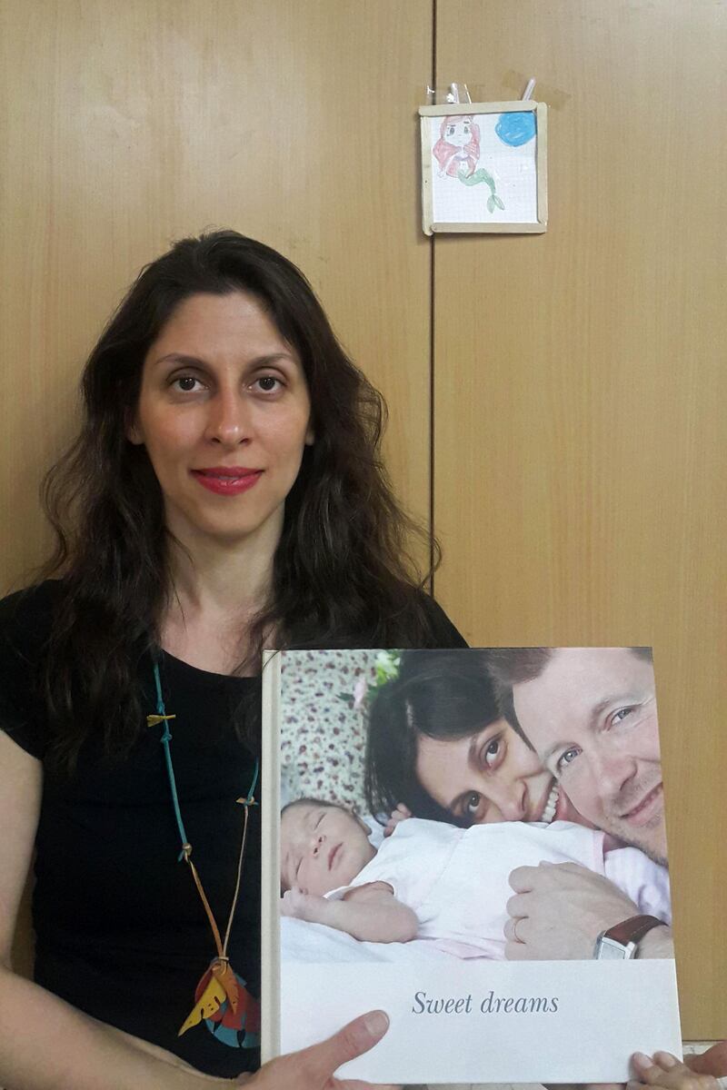 (FILES) In this file handout photo released by the Free Nazanin campaign on March 17, 2020, Nazanin Zaghari-Ratcliffe poses holding an old picture of herself with her husband and daughter as she poses for a photograph in West Tehran, Iran following her release from prison for two weeks.
 Iran has postponed a new trial due to start Sunday, September 13 of Nazanin Zaghari-Ratcliffe, a British-Iranian woman detained in Tehran for sedition, her husband said. - RESTRICTED TO EDITORIAL USE - MANDATORY CREDIT "AFP PHOTO / FREE NAZANIN CAMPAIGN" - NO MARKETING NO ADVERTISING CAMPAIGNS - DISTRIBUTED AS A SERVICE TO CLIENTS


 / AFP / Free Nazanin campaign / - / RESTRICTED TO EDITORIAL USE - MANDATORY CREDIT "AFP PHOTO / FREE NAZANIN CAMPAIGN" - NO MARKETING NO ADVERTISING CAMPAIGNS - DISTRIBUTED AS A SERVICE TO CLIENTS


