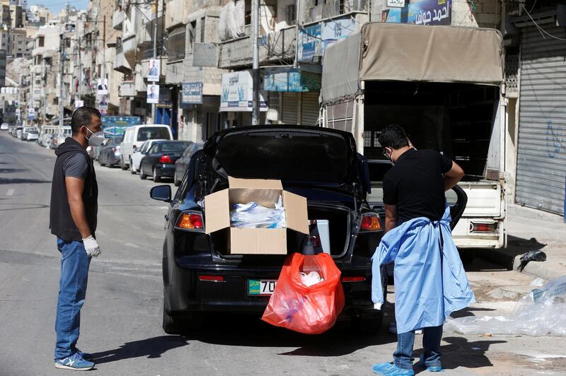 Jordanian healthcare workers throw away protective gear after taking nasal swab samples for the coronavirus at a neighborhood of Amman, during the nationwide curfew for two days, amid fears of a rising number of cases, Jordan. REUTERS