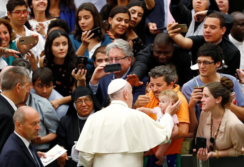 Pope Francis greets a child as he arrives to lead the general audience at the Paul VI Hall in Vatican, 1 August, 2018. REUTERS/Max Rossi
