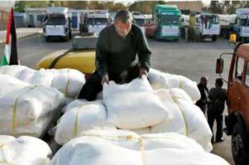 A worker loads humanitarian aid onto a truck before it departs for the Gaza Strip, at the King Hussein Bridge crossing near Amman, December 29, 2008. REUTERS/Muhammad Hamed (JORDAN) *** Local Caption ***  AMM06x_JORDAN-_1229_11.JPG