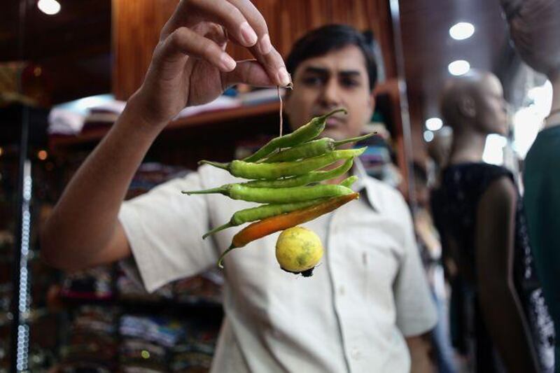 Gopi Purohit with a string of chillies and a lemon he will hang in his clothing shop in the Meena Bazaar.