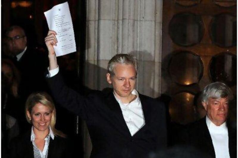 Julian Assange celebrates outside the High Court in central London after being granted bail yesterday.