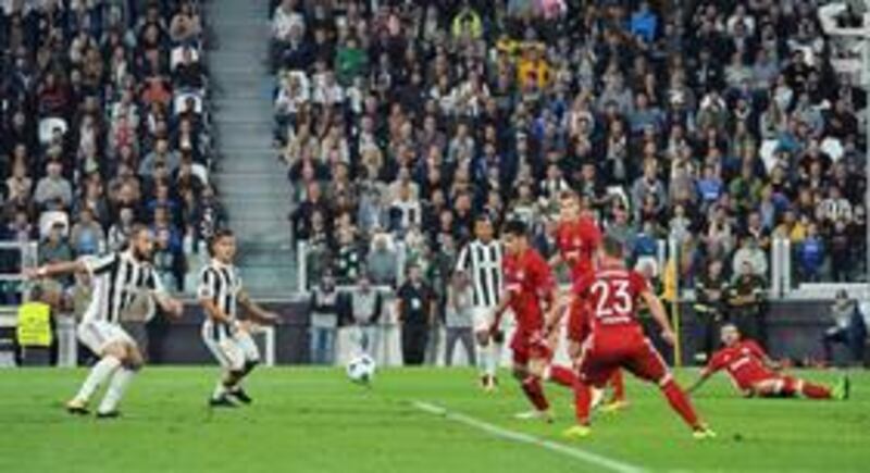 Juventus' Gonzalo Higuain, left, scores during the Champions League group D soccer match between Juventus and Olympiakos, at the Allianz stadium in Turin, Italy (Alessandro Di Marco/ANSA via AP)