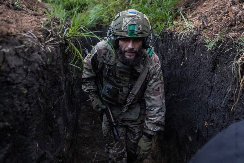 A Ukrainian soldier moves along a trench at a position near the front-line town of Bakhmut. Reuters