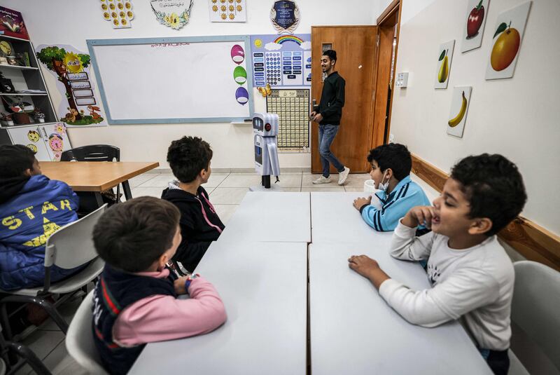 Teacher Hassan Al Rozy takes a science class with the help of one of the robots.