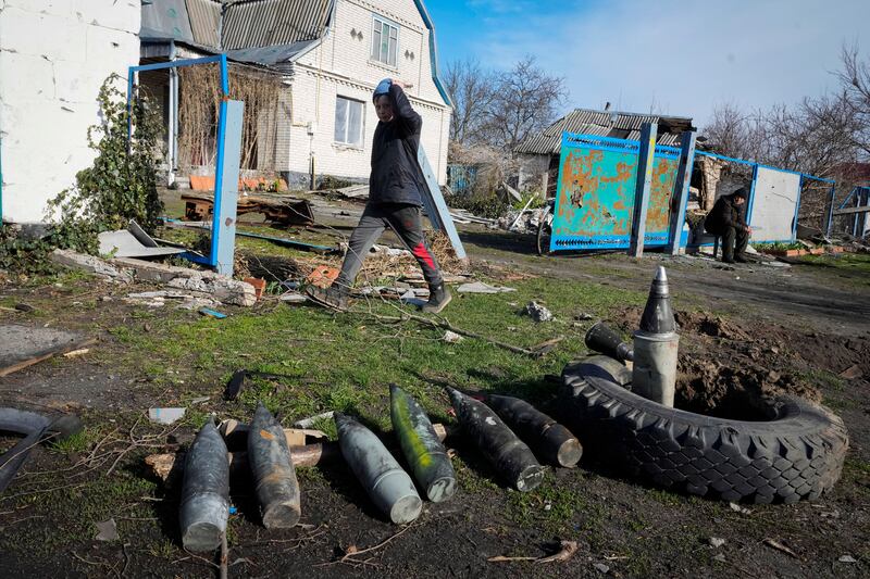 A boy walks by unexploded Russian shells in the village of Andriyivka close to Kyiv, Ukraine. AP