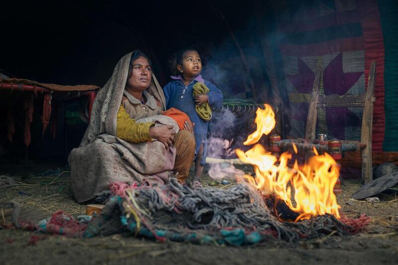 A woman and her children keep warm in a slum in Sahiwal, Pakistan. Courtesy Sohail Karmani