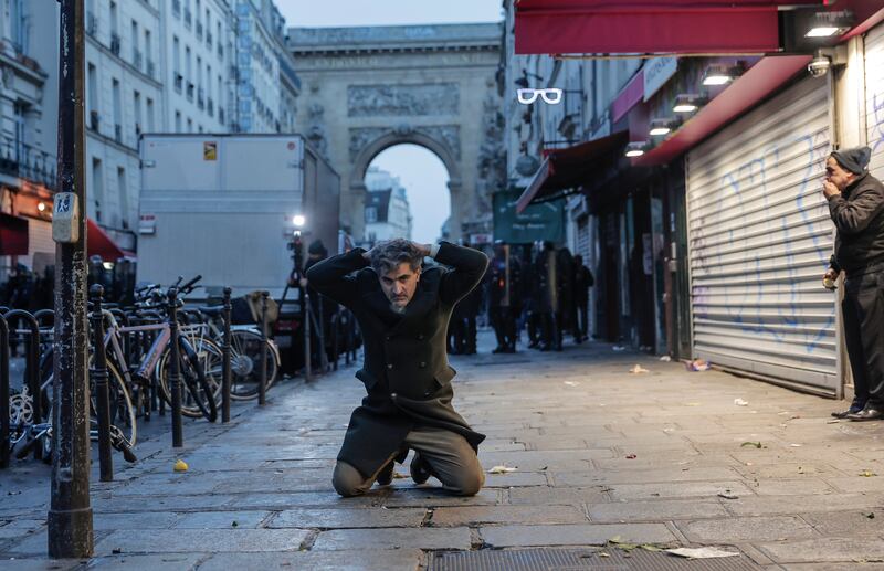A protester kneels on the ground after he was detained during the clashes. AP