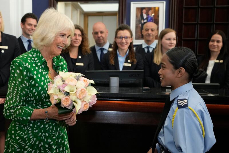 Queen Camilla receives flowers from Cadet Sgt Nahien Islam at the Royal Air Force Club. PA
