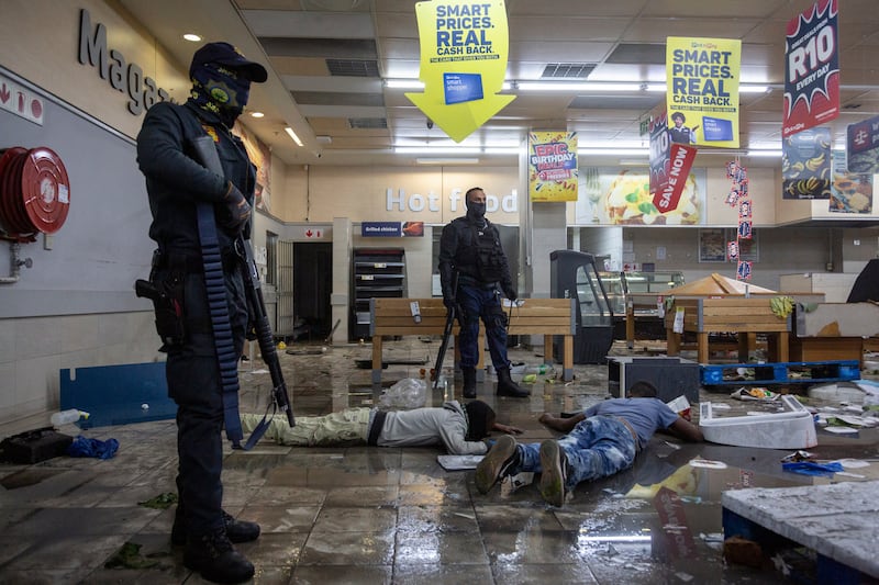 Police stand over suspected looters in a shopping centre in Alexandra township, Johannesburg. Those backing Mr Zuma's claim he is the victim of a political witch-hunt orchestrated by allies of his successor, President Cyril Ramaphosa.