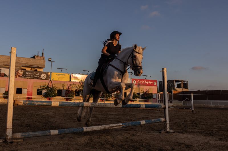 A teenage girl practises showjumping at Friends Equestrian Club.