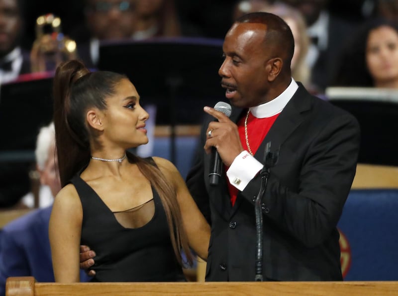 Bishop Charles H. Ellis, III, right, speaks with Ariana Grande after she performed during the funeral service for Aretha Franklin at Greater Grace Temple, Friday, Aug. 31, 2018, in Detroit. Franklin died Aug. 16, 2018 of pancreatic cancer at the age of 76. (AP Photo/Paul Sancya)
