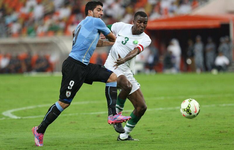 Luis Suarez of Uruguay fights for the ball with Osama Hawsawi of Saudi Arabia in a friendly on Friday at King Abdullah Stadium in Jeddah. AP Photo / October 10, 2014