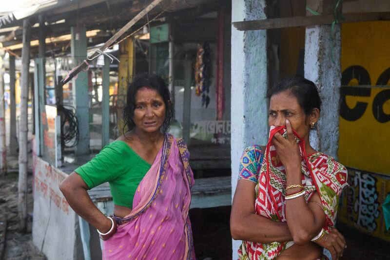Two women react as they look at the damages caused by Cyclone Bulbul in Bakkhali on November 10, 2019. Three people have died and two million others spent a night huddled in storm shelters as Cyclone Bulbul smashed into the coasts of India and Bangladesh with fierce gales and torrential rains, officials said on November 10. / AFP / Dibyangshu SARKAR
