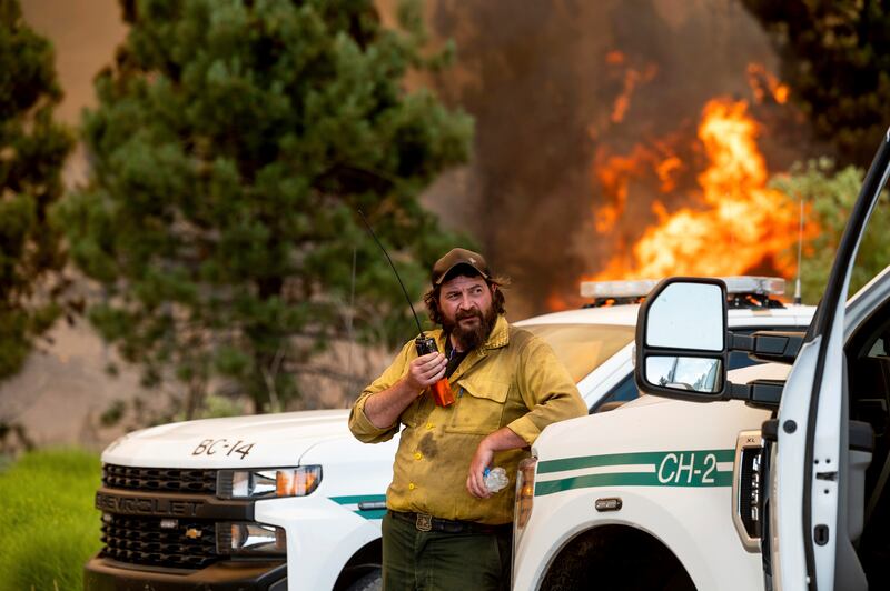 US Forest Service firefighter Chris Voelker monitors a fire burning in Plumas National Forest, California.
