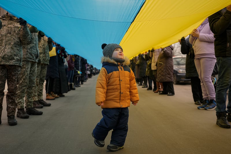 A child walks under a large Ukrainian flag carried by people in Sievierodonetsk, the Luhansk region, eastern Ukraine. AP Photo