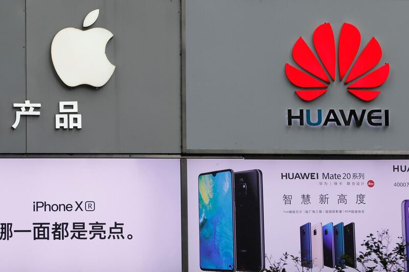 FILE - In this Thursday, March 7, 2019, file photo, logos of Apple and Huawei are displayed outside a mobile phone retail shop in Shenzhen, China's Guangdong province. Few U.S. companies are more vulnerable to a trade war with China than Apple. The Trump administrationâ€™s decision to bar U.S. technology sales to Huawei, one of Chinaâ€™s leading brands, might put Apple in the crosshairs. (AP Photo/Kin Cheung, File)