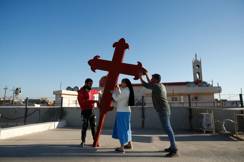 Iraqi Christians place a cross on a church in Qaraqosh, Iraq.  AP Photo